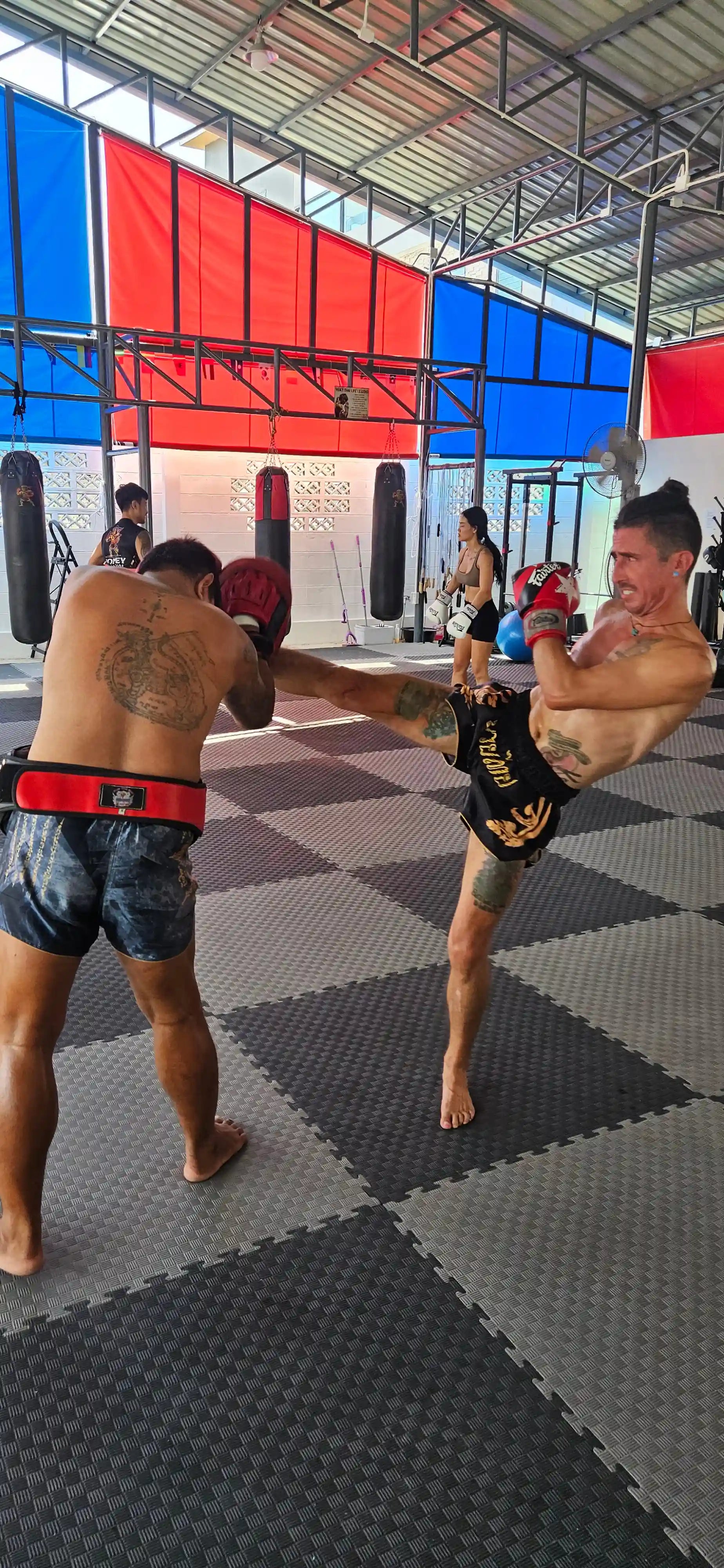 Black Gold Muay Thai shorts – fighter full body shot in premium gold trim shorts – shop elite fight wear Thailand
