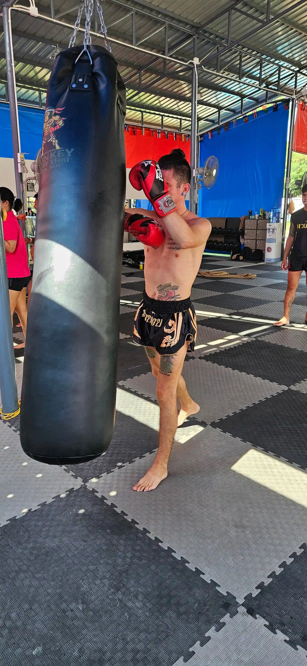 Black Gold Muay Thai shorts – fighter executing powerful kick technique – buy competition fight gear Thailand
