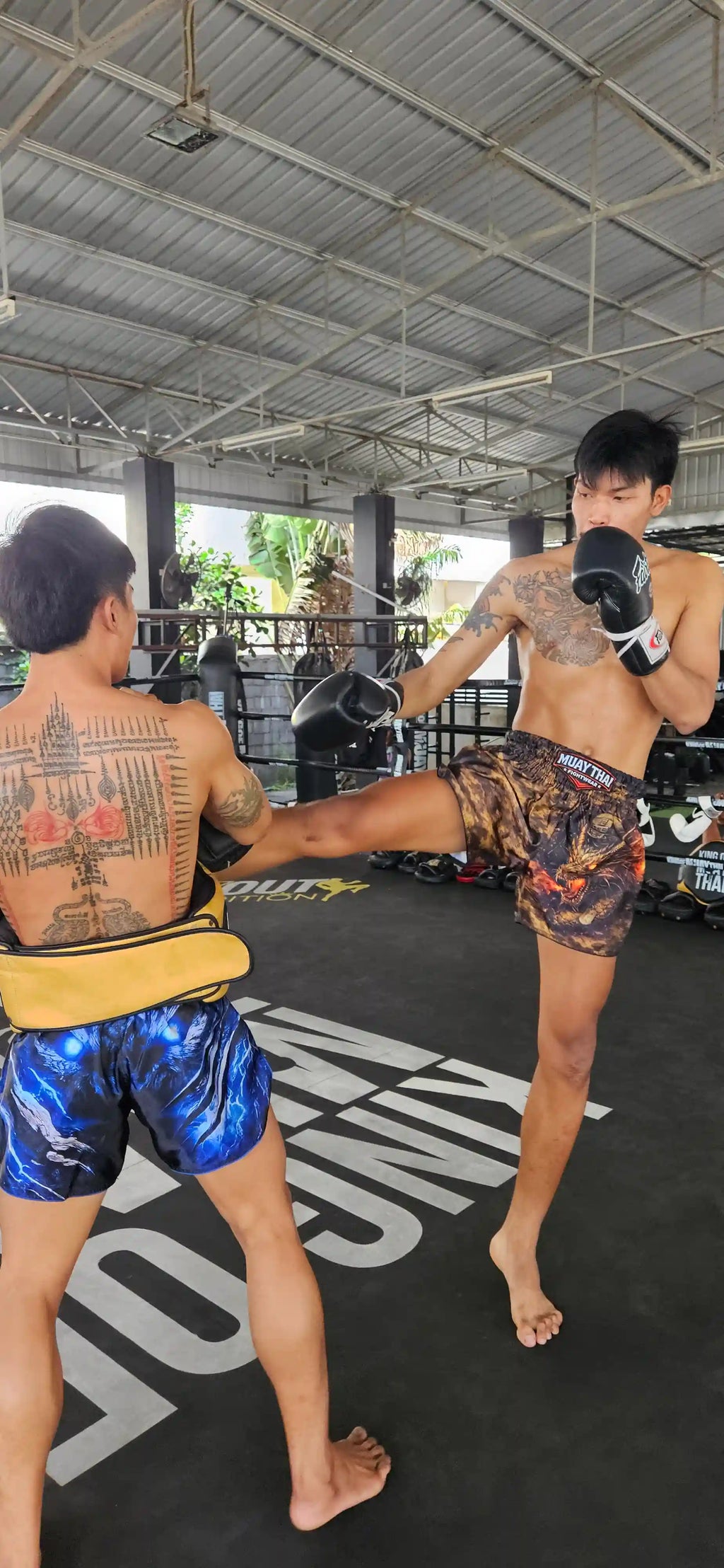 Storm Beast Muay Thai shorts – fighter executing powerful knee strike – buy competition fight gear Thailand
